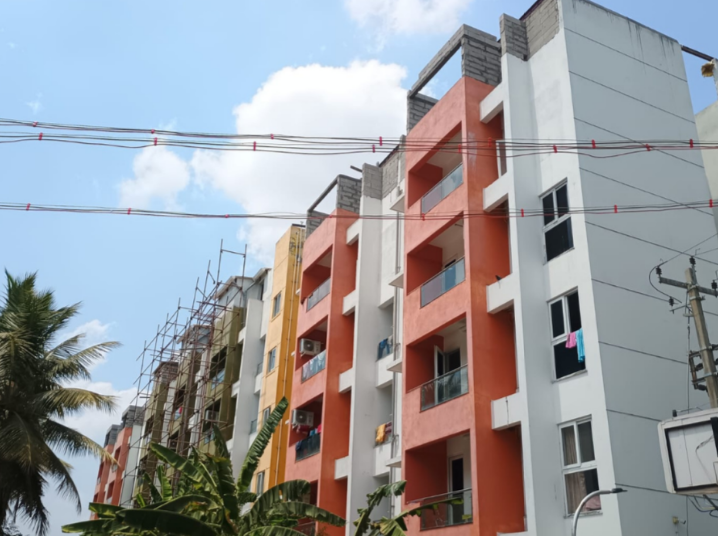 Exterior view of the multi-story Sukino Inpatient Rehabilitation Center building in Sowri Palayam, featuring modern orange balconies and grey siding against a partly cloudy sky.