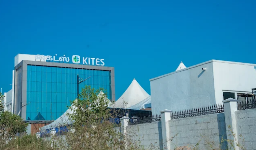 Exterior view of the modern, blue-and-white building facade for KITES Senior Care in Saravanampatti, Coimbatore, set against a clear blue sky.